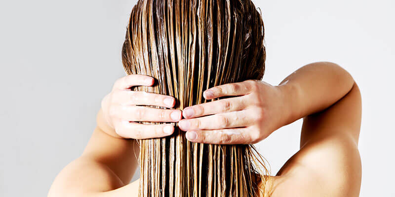 Woman applying conditioner for hair extensions